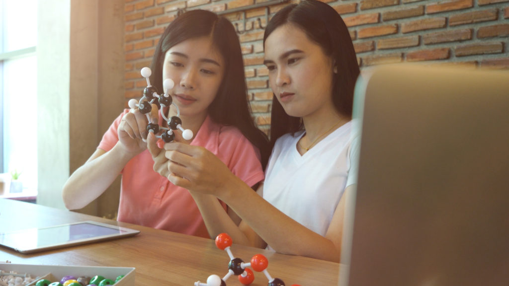 Two girls learning on chemistry subject