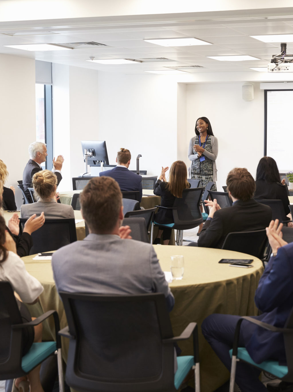 audience-applauding-businesswoman-making-presentation