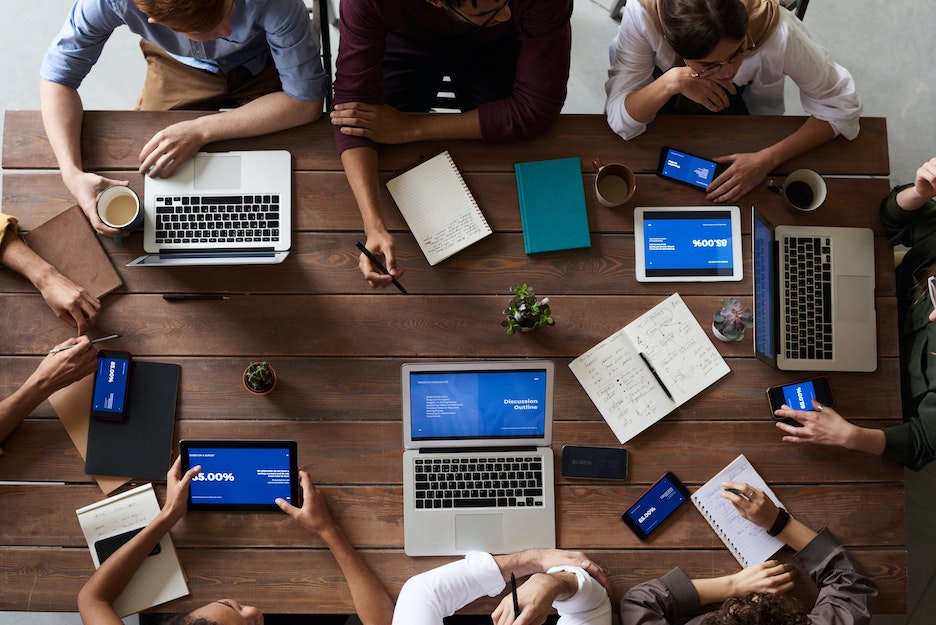 Employees at table with laptops