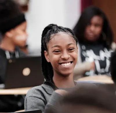 a student sitting smiling in class