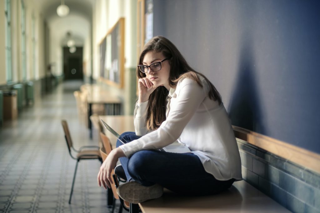 sad teen girl sitting on a desk
