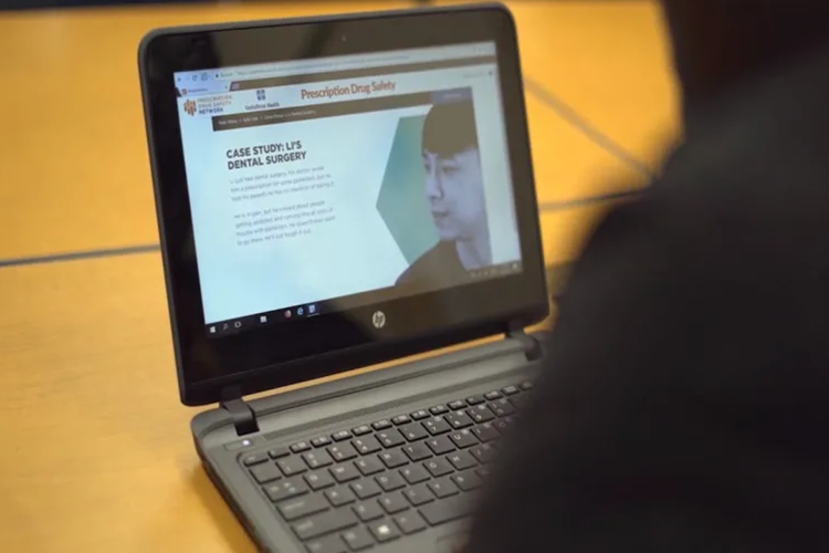 behind view of student look at a case study on their laptop