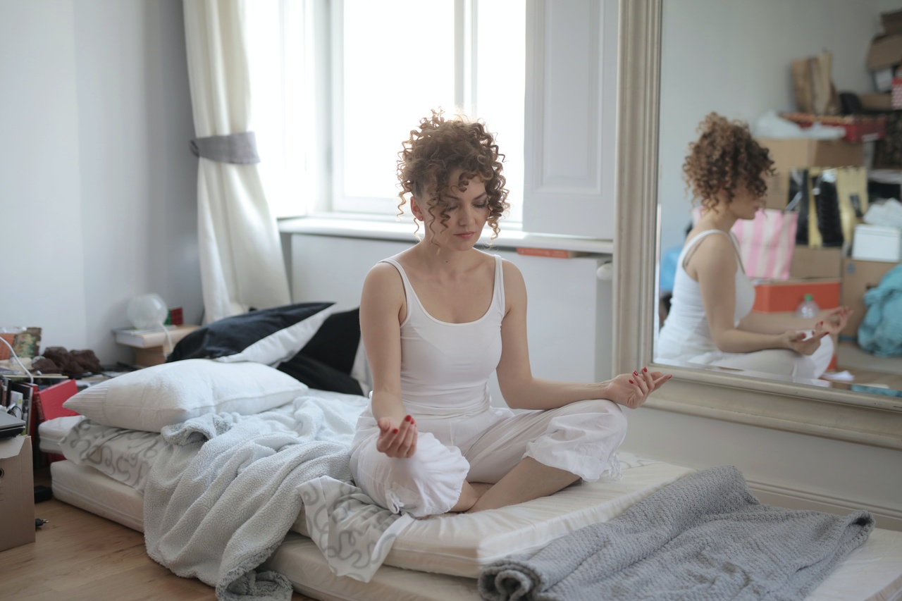 girl meditating in bedroom