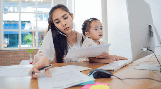 Mother working next to her child