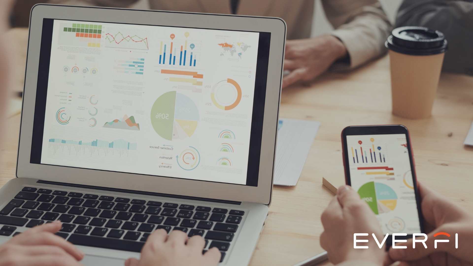 Hands working on a laptop and a mobile