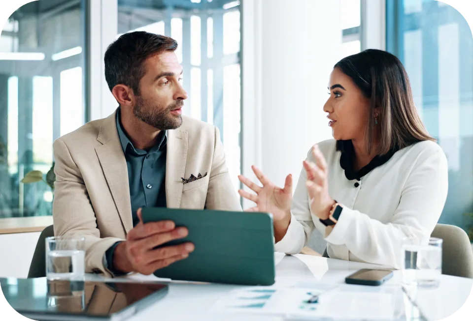 Two colleagues discussing at desk