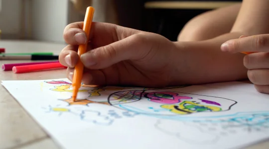 Child drawing with markers
