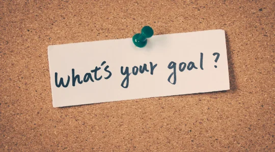 "What's your goal?" written on note tacked to cork board