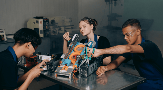 High school students building robot together in lab
