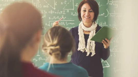 Smiling teacher at front of classroom