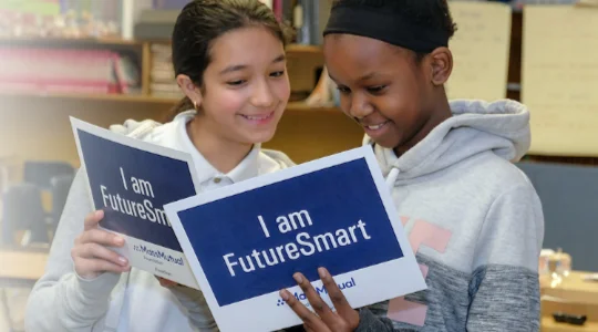 Two young female students reading FutureSmart materials together