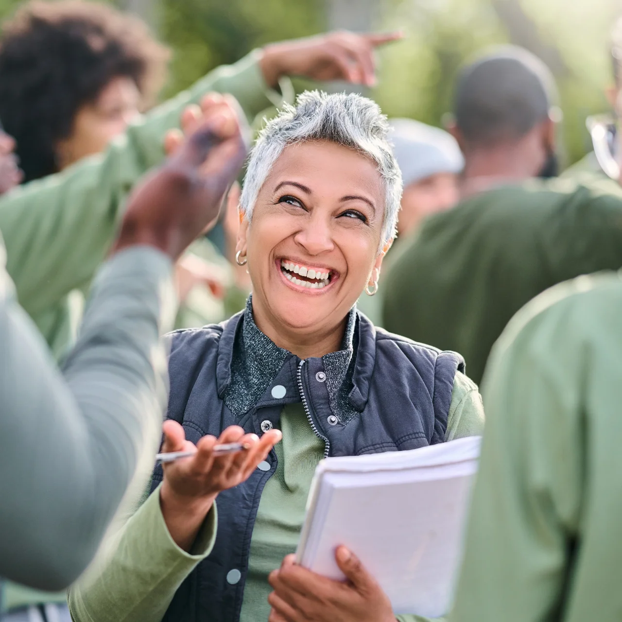Person laughing and shrugging while handing out flyers