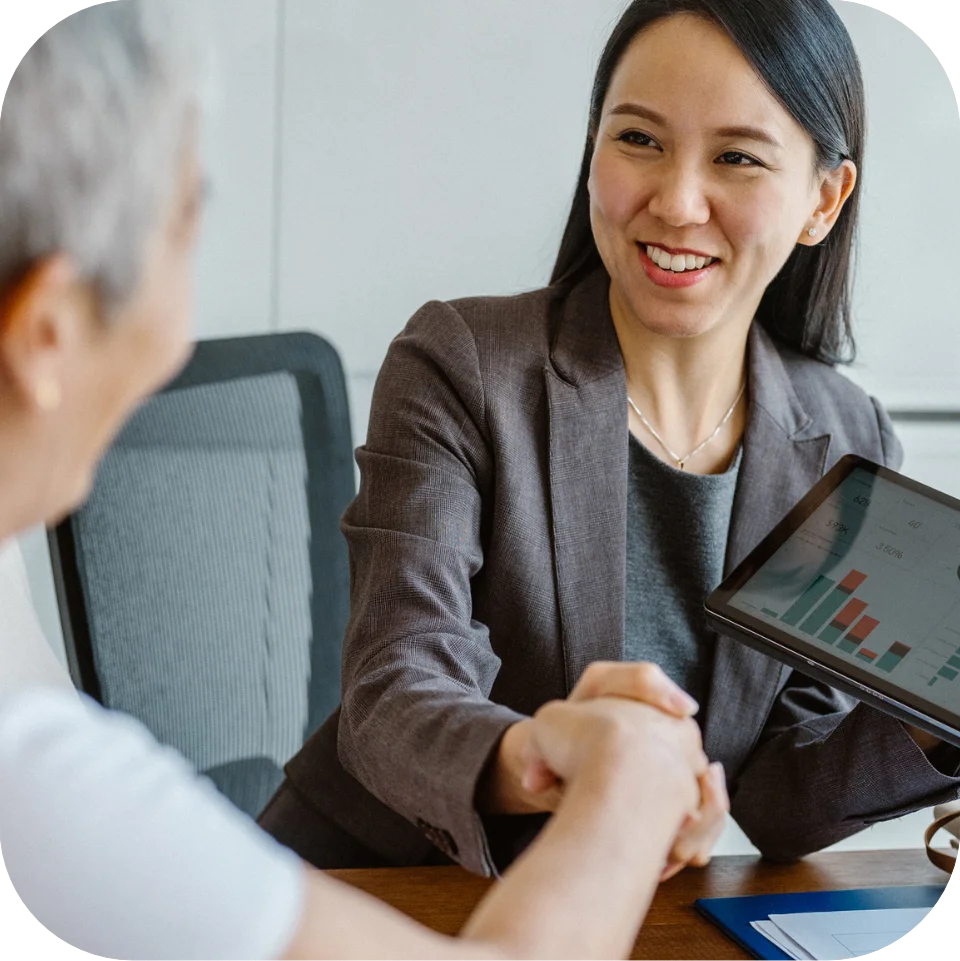 Account manager shaking hands with client after reviewing numbers