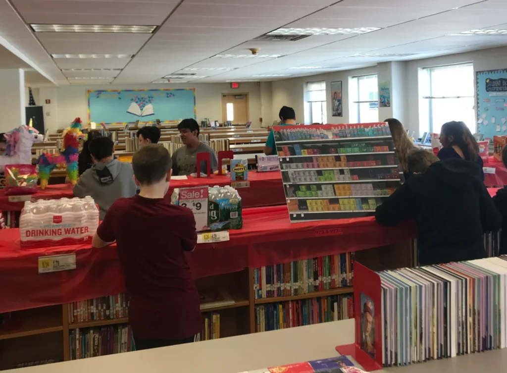 Students look at shopping supplies in a school library