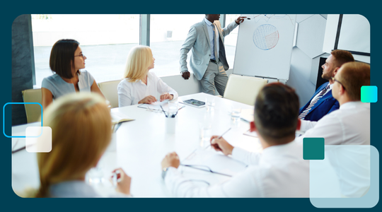 A business professional gives a presentation with a pie chart to colleagues in a conference room, representing the strategic planning for a bank's CRA initiatives.