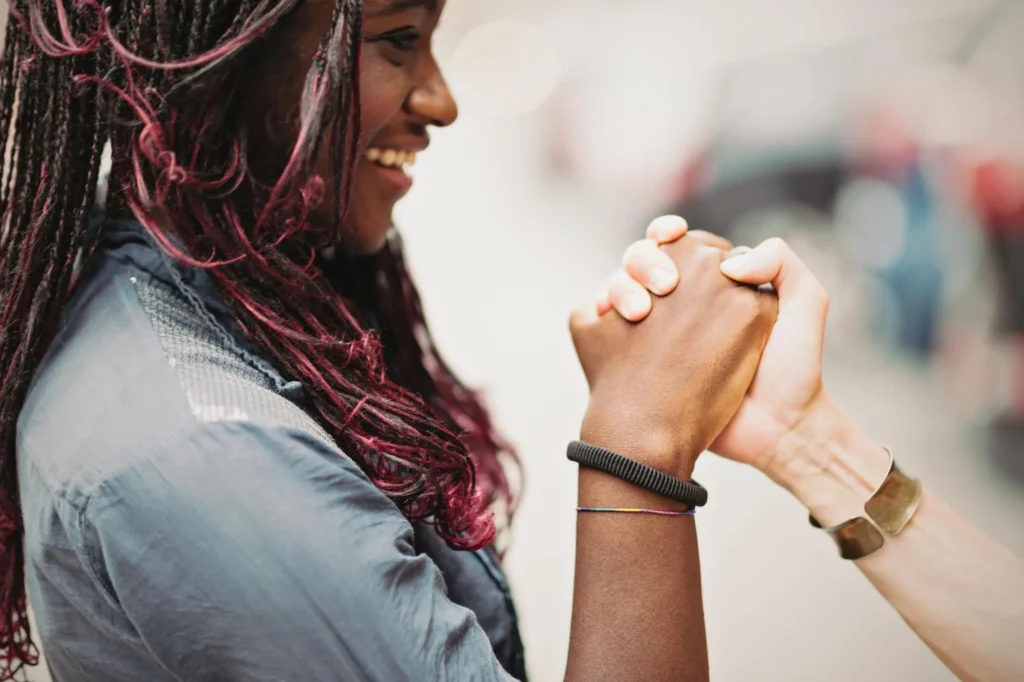 Woman smiling and holding another hand