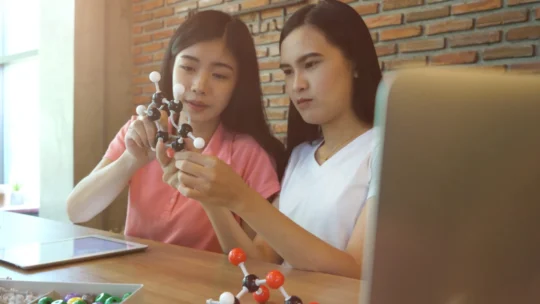 Two students looking at chemistry molecules
