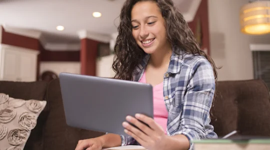 Young woman smiling while using tablet
