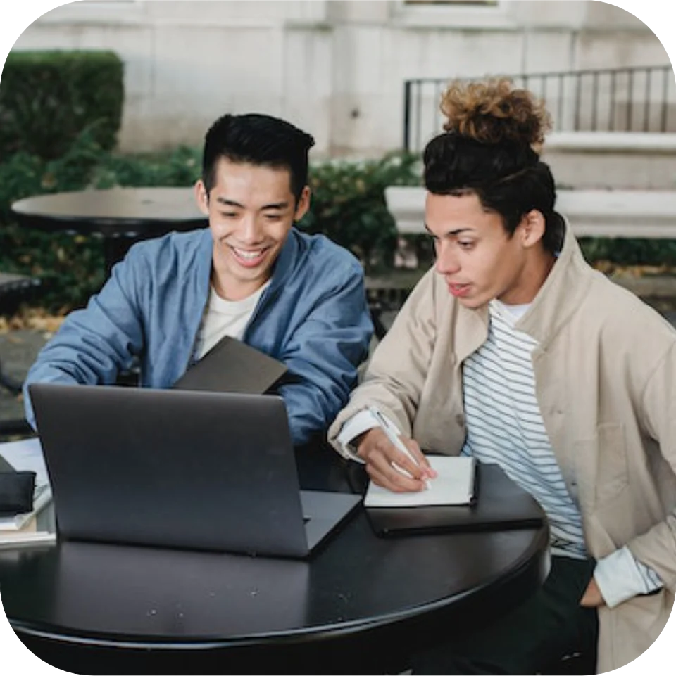 Two college students working on laptop together