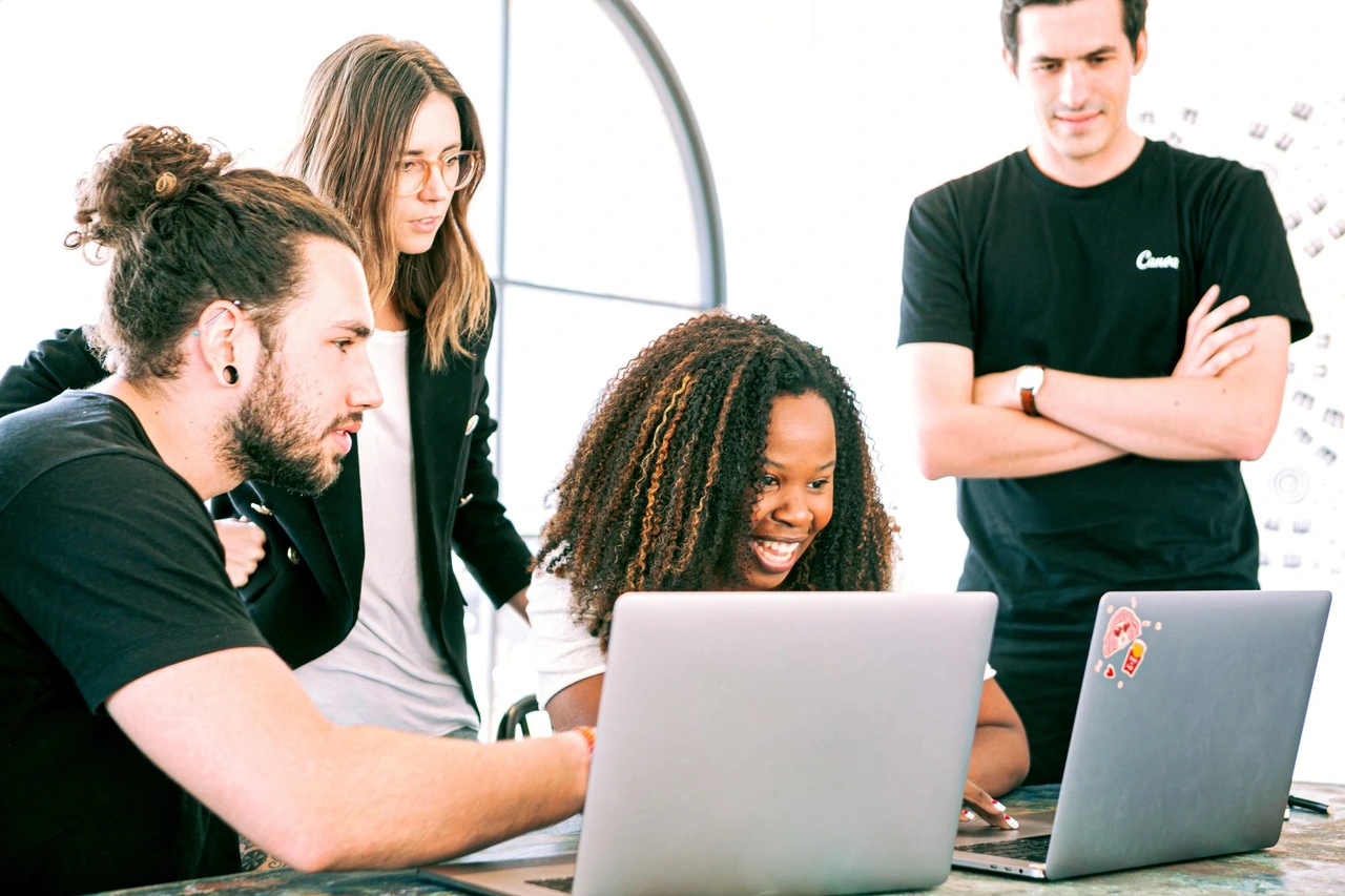 Team of millennials discussing ideas on computers
