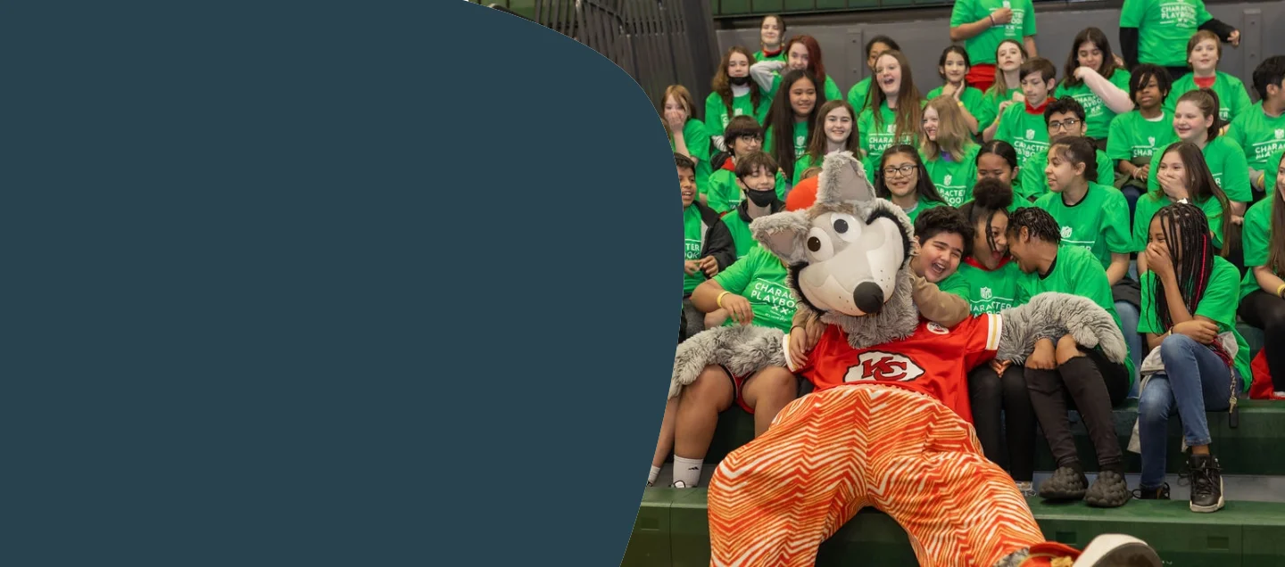 Students gathered with pro sports mascot on bleachers