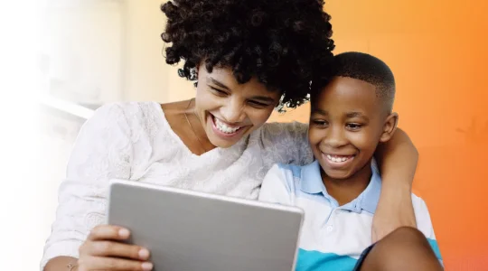 Mother and son smiling while using tablet