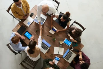 employees sitting at a table working on laptops