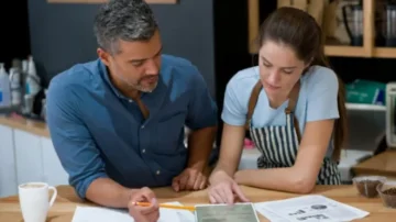 Boss and employee reviewing marketing materials