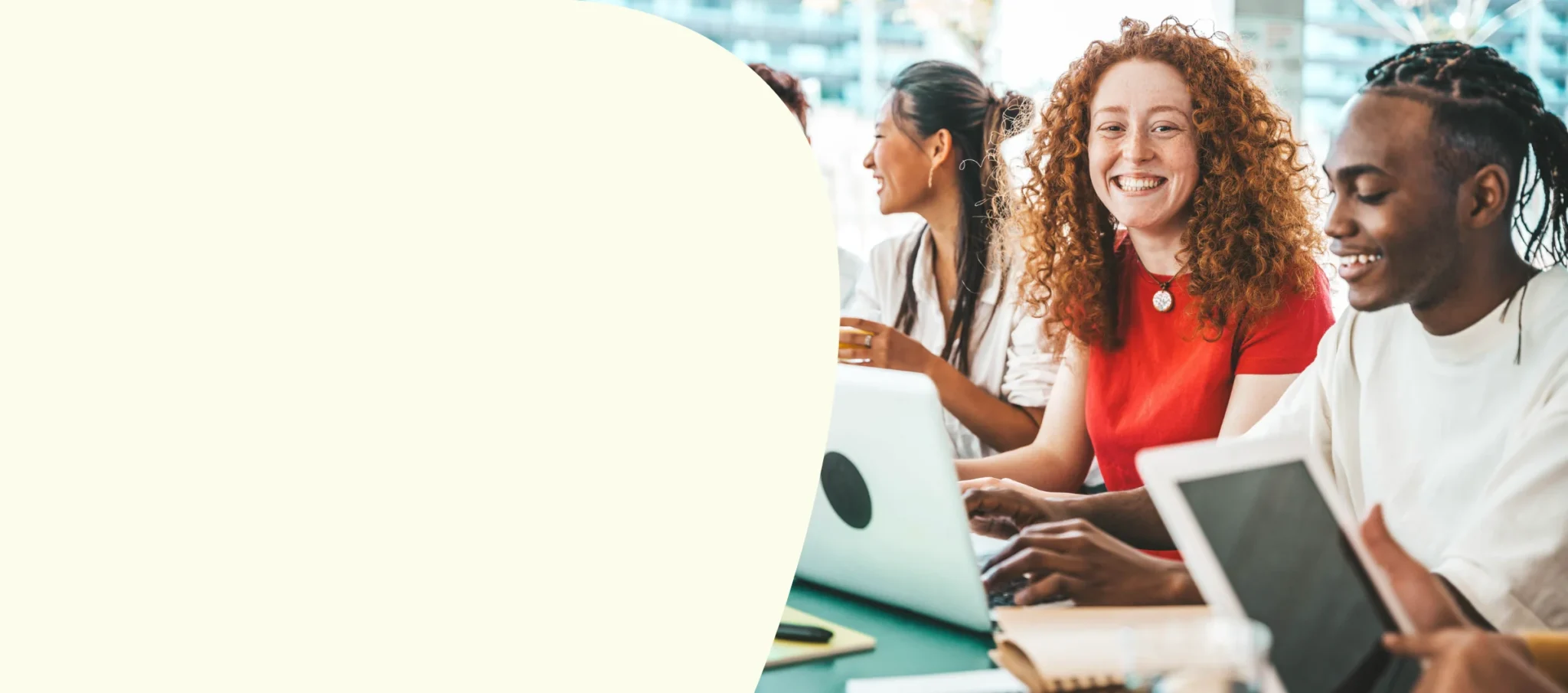 College students smiling while using laptops together