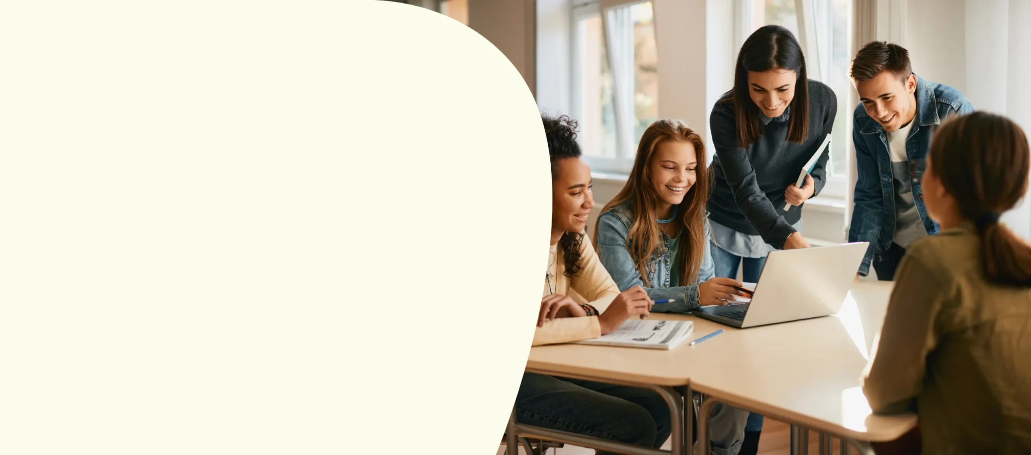 High school students gathered around laptop to work on project