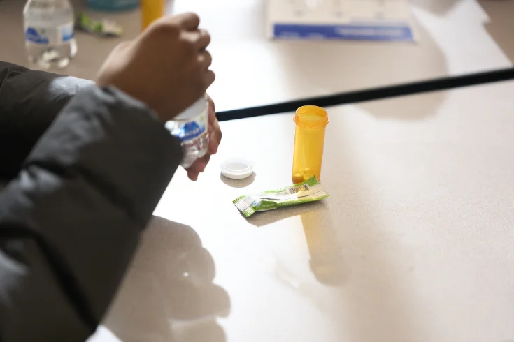 Person taking prescription medication with water