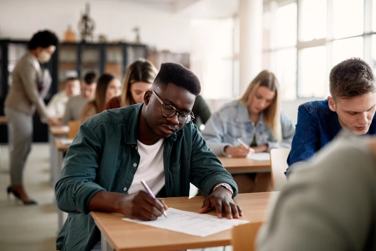 High school student writing at desk