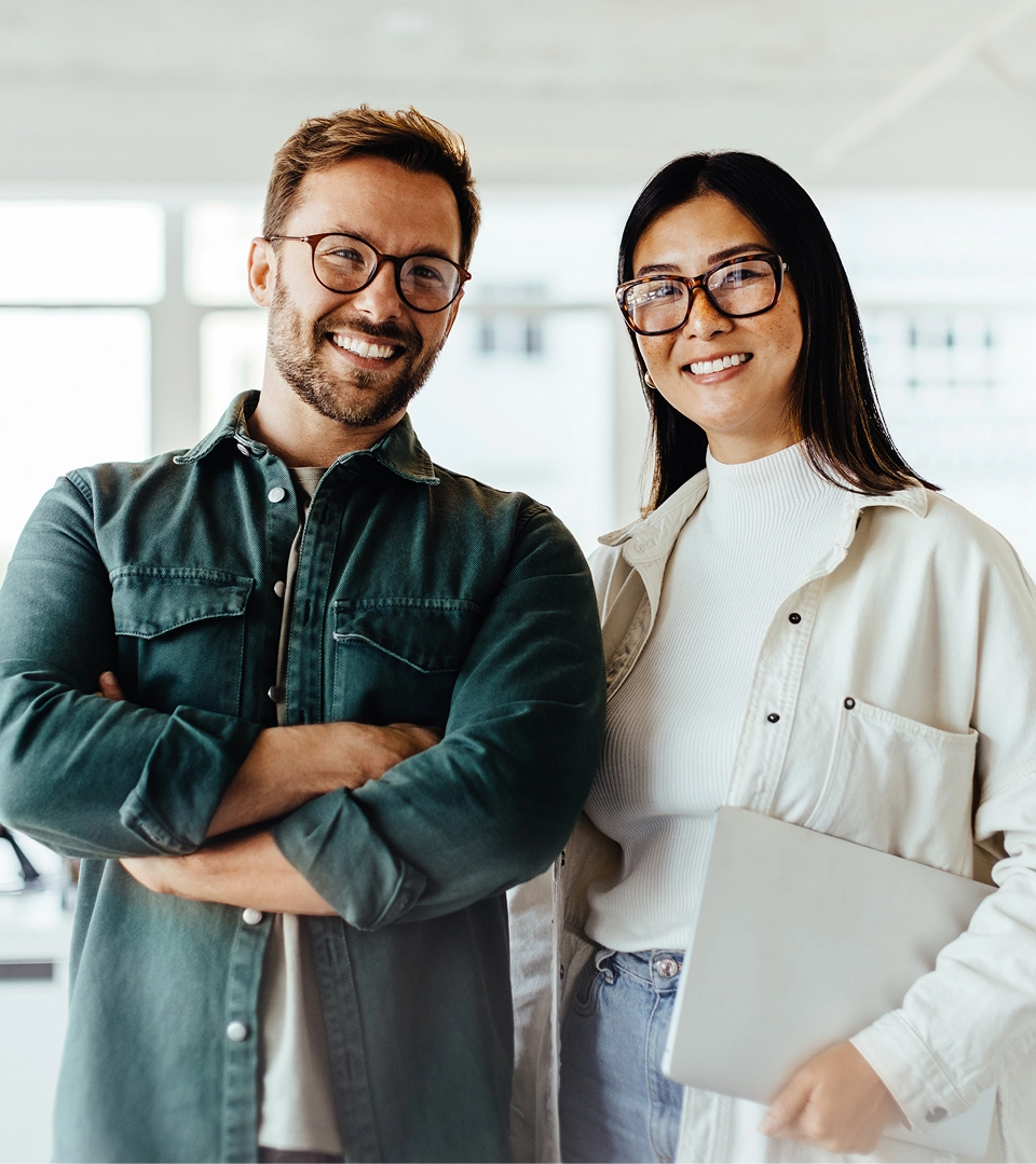 Two young professionals standing together and smiling